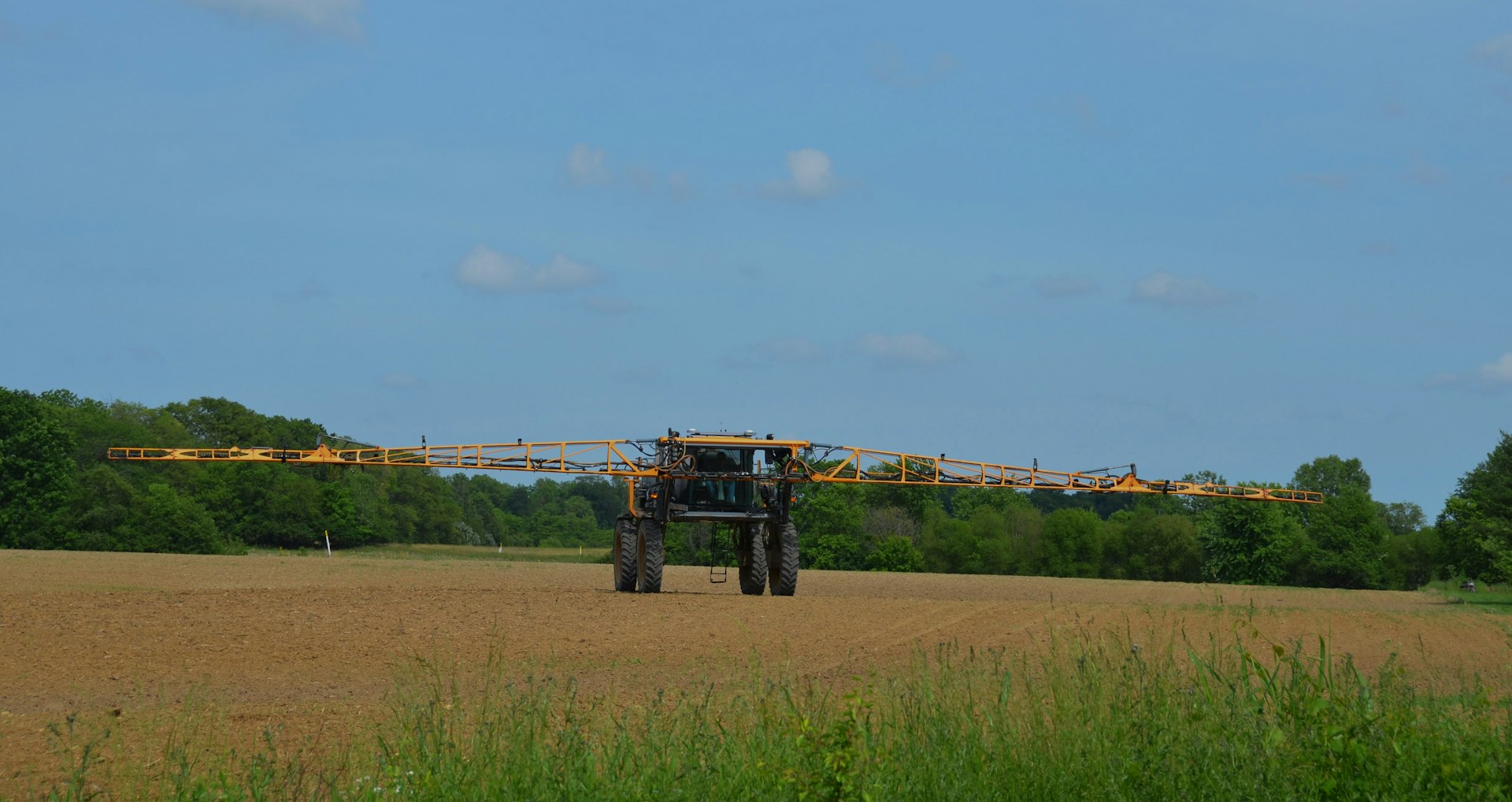 a tractor in a field with trees in the background